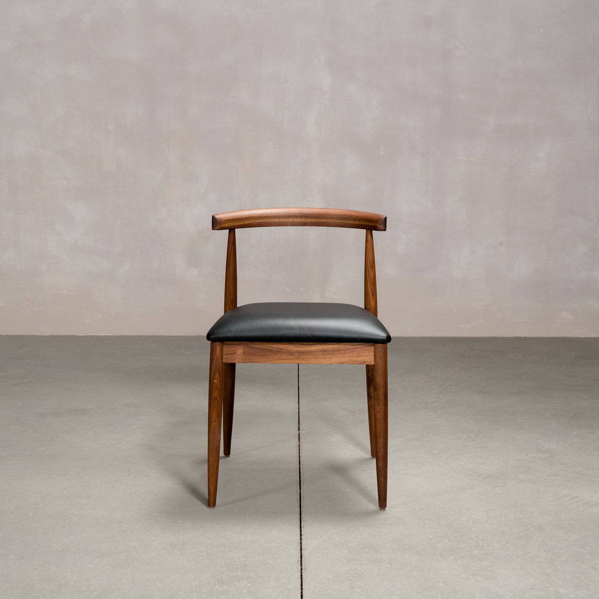 midcentury modern Walnut dining chair with an Onyx Faux Leather seat