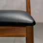 seat detail of a midcentury modern Walnut dining chair with an Onyx Faux Leather seat