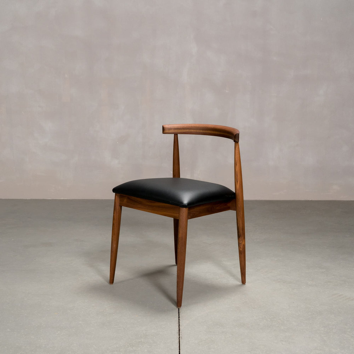 midcentury modern Walnut dining chair with an Onyx Faux Leather seat