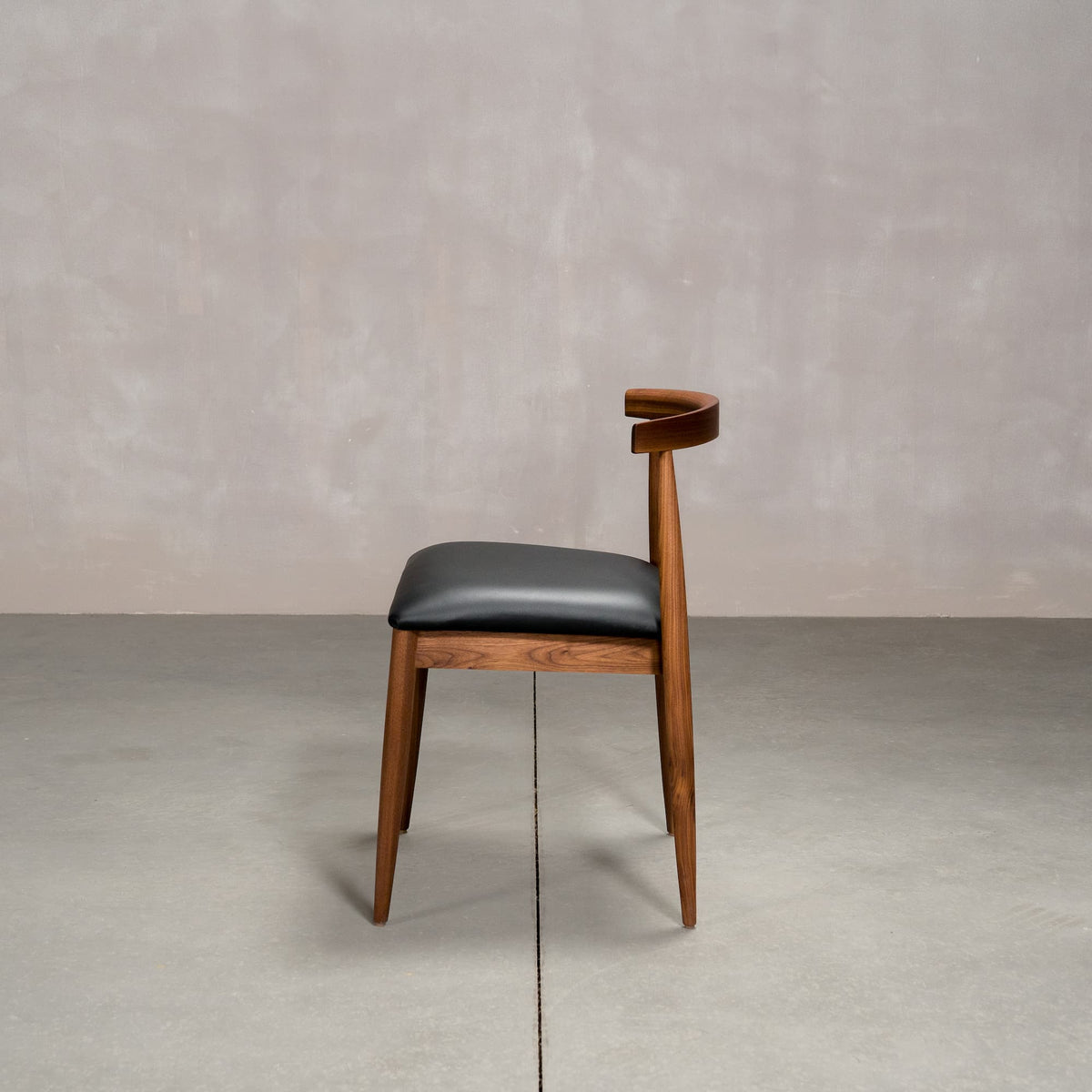 midcentury modern Walnut dining chair with an Onyx Faux Leather seat