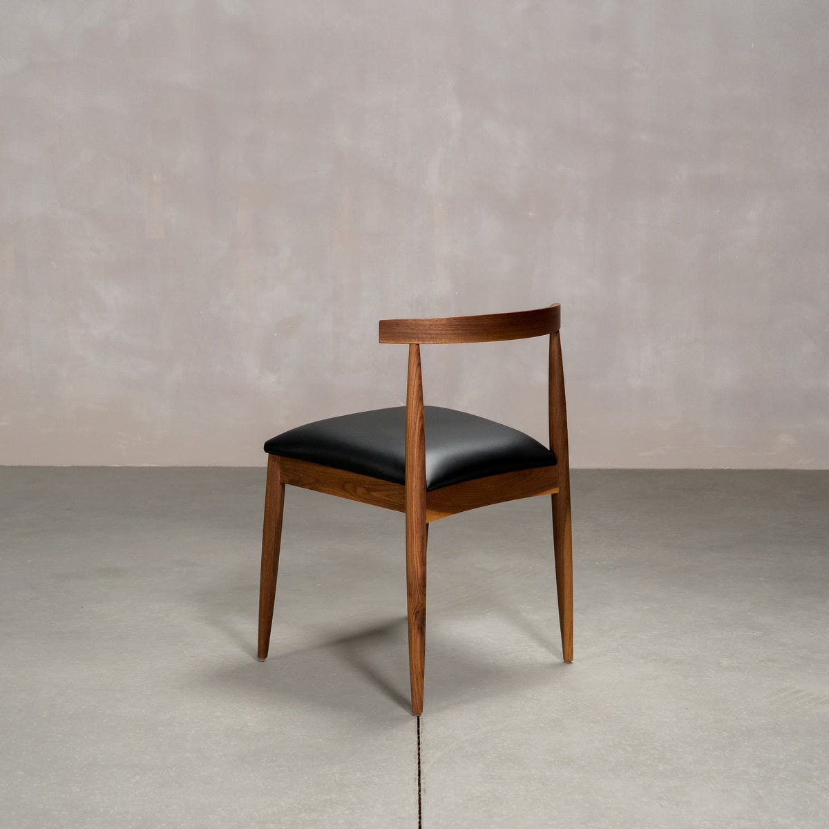 midcentury modern Walnut dining chair with an Onyx Faux Leather seat