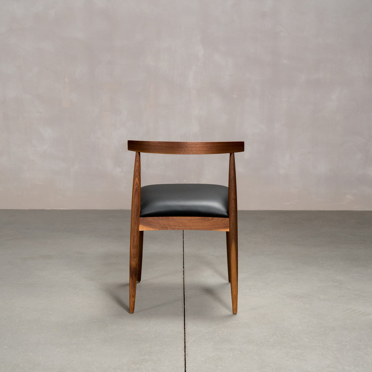 midcentury modern Walnut dining chair with an Onyx Faux Leather seat
