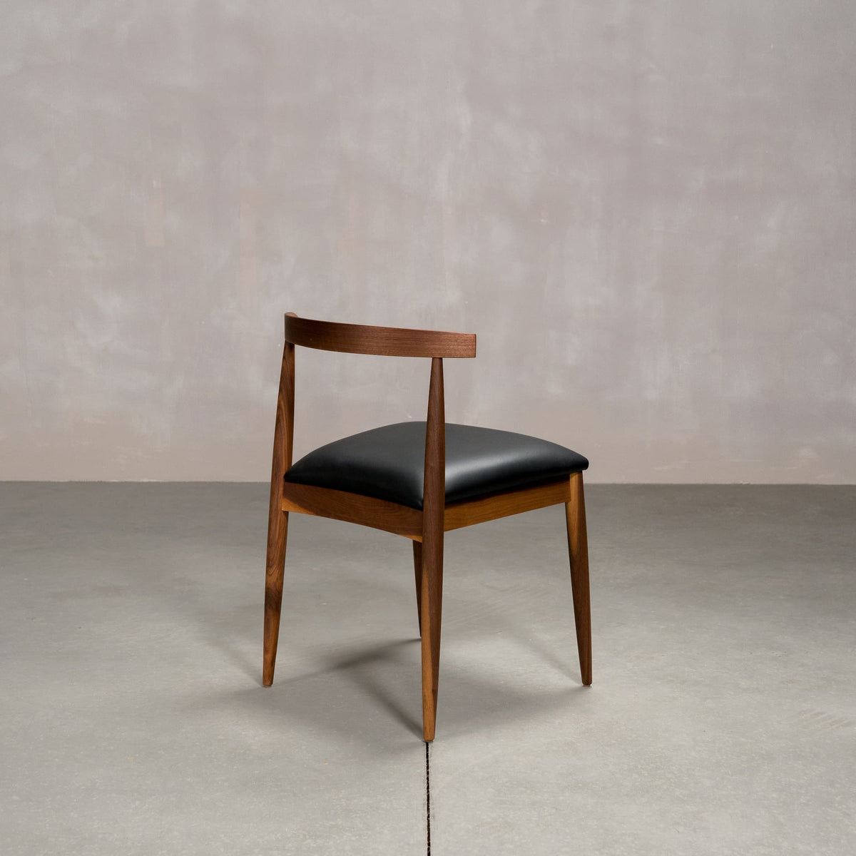 midcentury modern Walnut dining chair with an Onyx Faux Leather seat