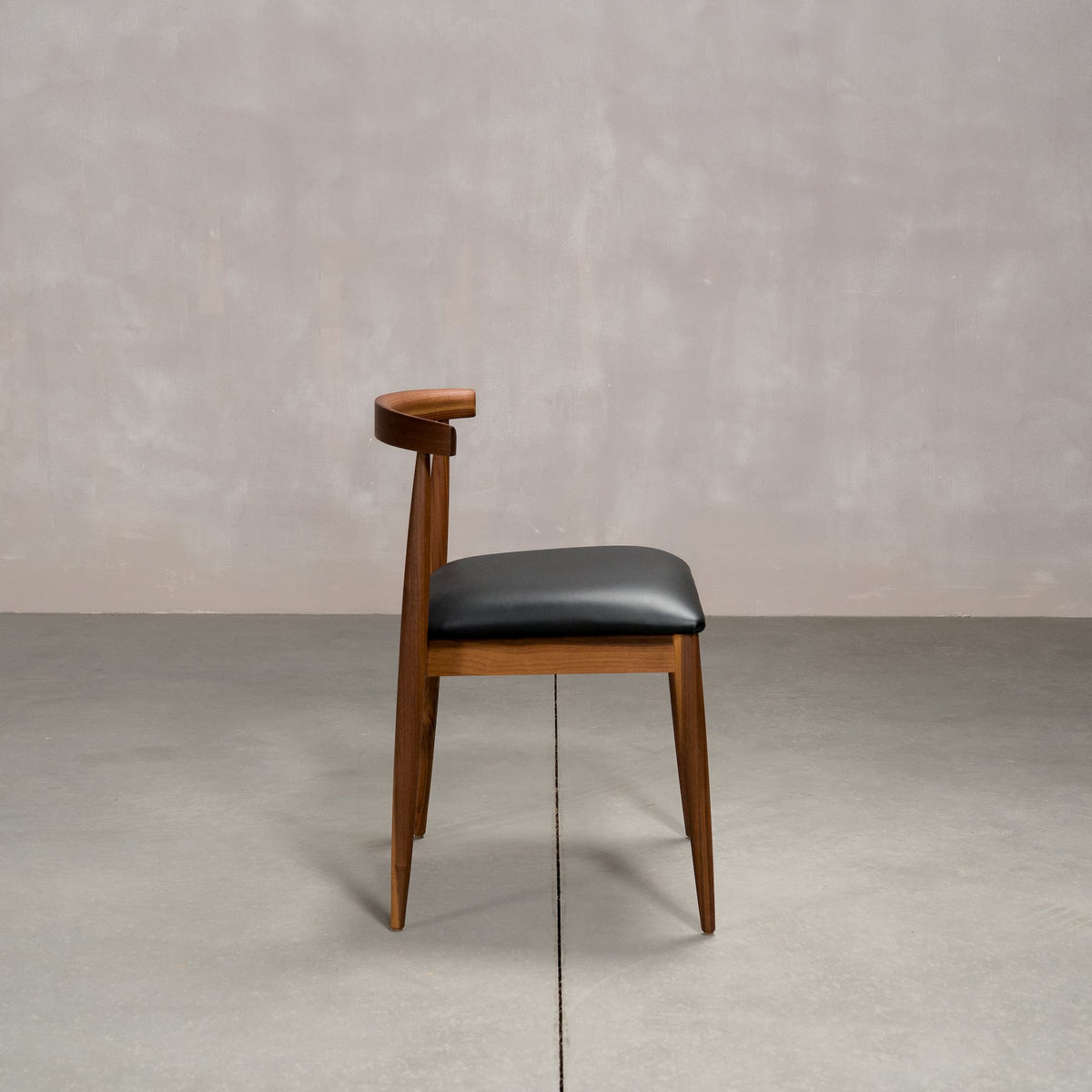 midcentury modern Walnut dining chair with an Onyx Faux Leather seat