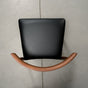 overhead view of a midcentury modern Walnut dining chair with an Onyx Faux Leather seat
