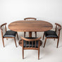 Oval dining table with Walnut dining chairs with black top grain leather seats