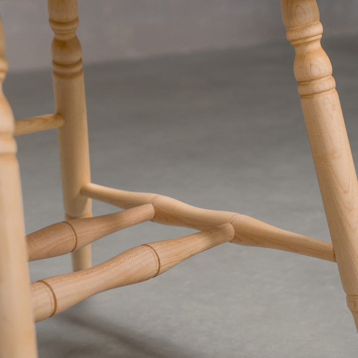 base detail on a hoop back dining chair with arms made of Maple with a Pure D finish