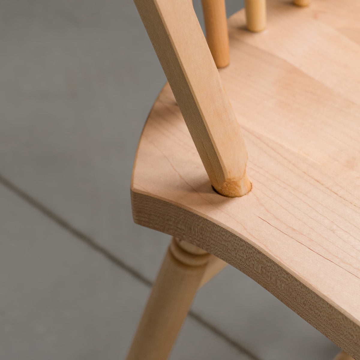 close up of a hoop back dining chair made of Maple with a Pure D finish