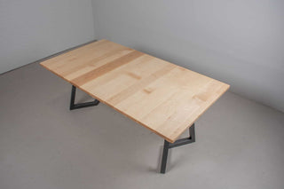 Scandinavian dining table with light colored square top at extended size of 42x76 on black steel chevron legs