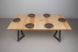 Scandinavian dining table with light colored square top at 42x76 size on black steel chevron legs with 6 plates 