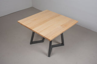 Scandinavian dining table with light colored square top that extending from 42x42 to 42x76 on black steel chevron legs