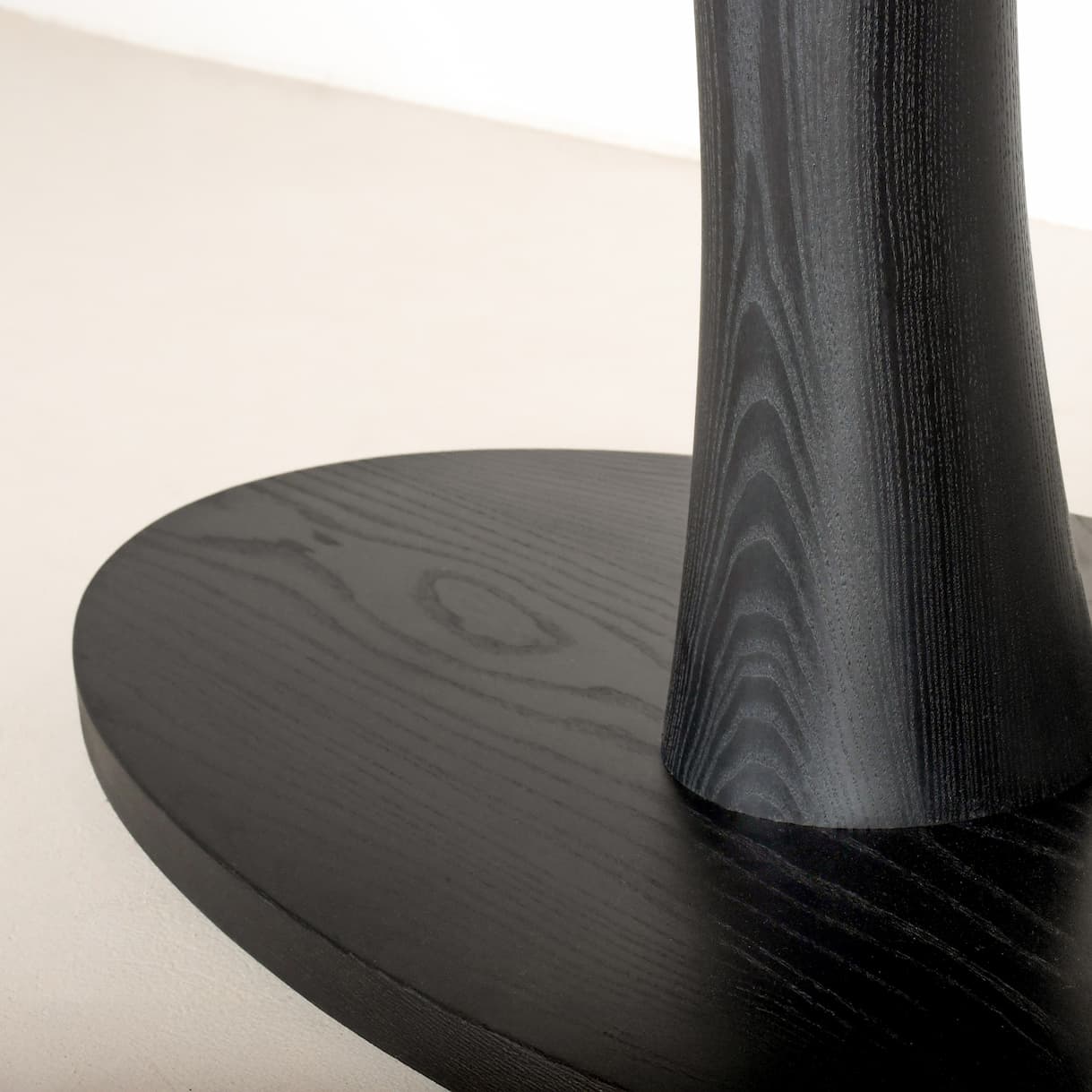 close up of pedestal base for a black ash table