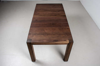 blackened walnut extendable table on modern exposed parsons base