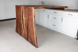 bar height bookmatch waterfall table in walnut attached to a counter