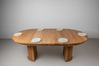 expandable round dining table in natural oak on split pedestal base
