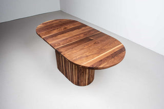 extendable oval table in walnut on a fluted walnut pedestal base