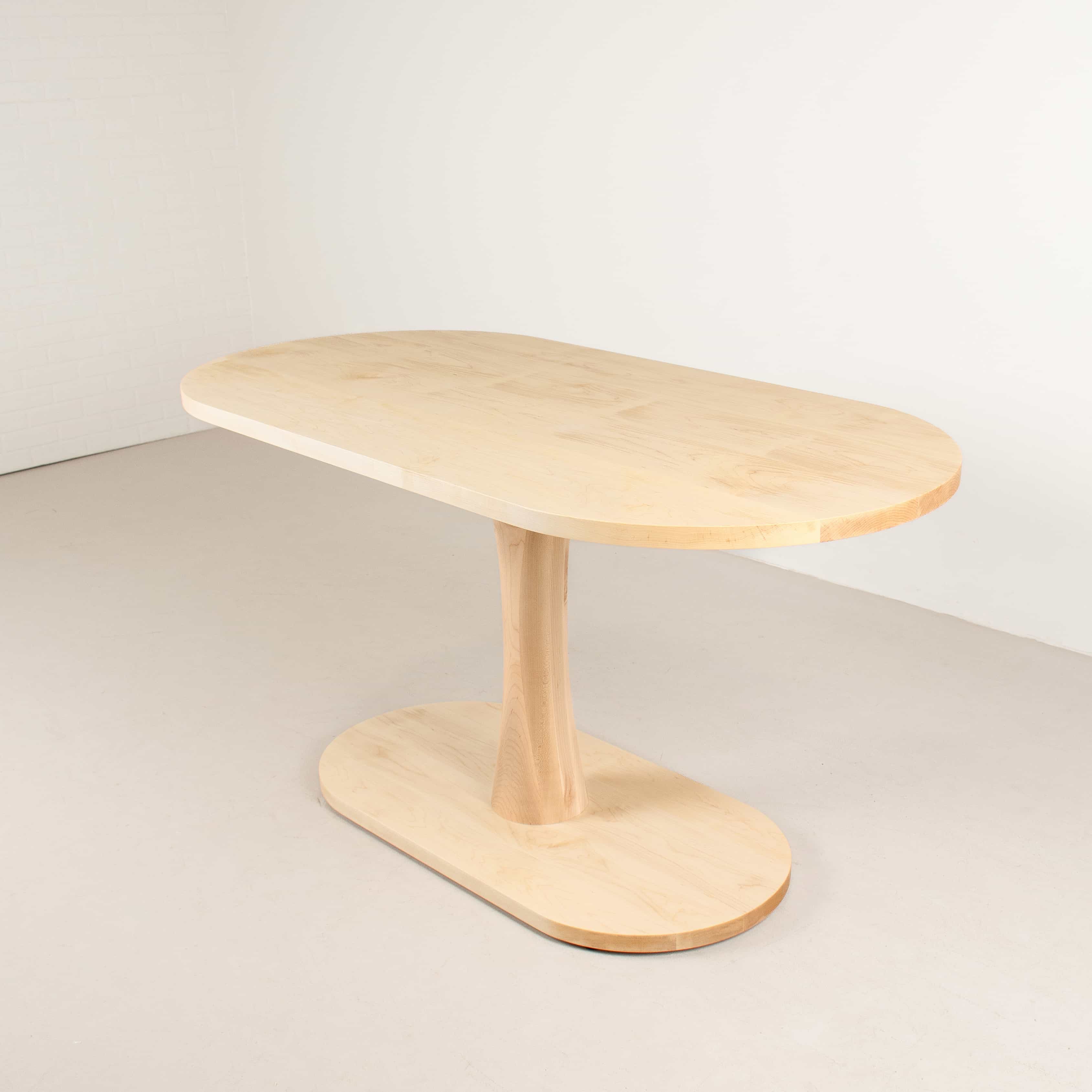 small oval dining table in maple on pedestal base