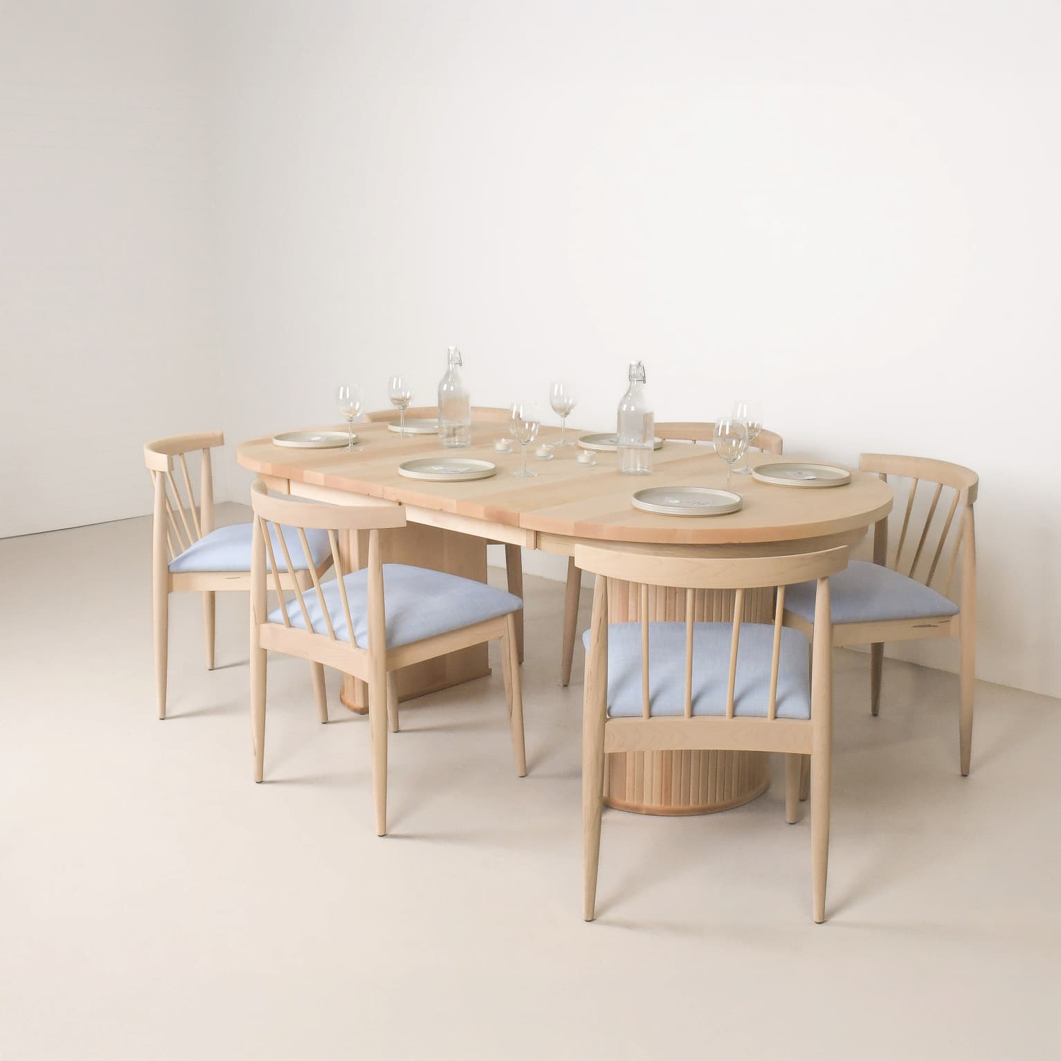 Wooden dining table with four chairs in a minimalistic setting