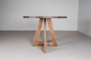 mid century oval table in walnut on single cross pedestal base