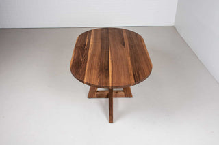 mid century oval table in walnut on single cross pedestal base