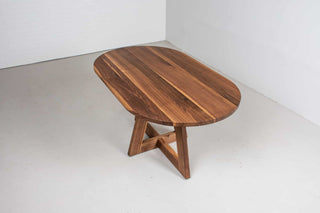 mid century oval table in walnut on single cross pedestal base