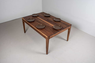 minimalist walnut dining table with a custom parsons base that is flush with the table top and has tapered legs