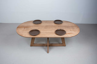 oval maple table finished in coconut on cross pedestal base