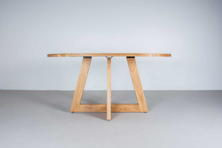 oval white oak dining table on single cross pedestal base