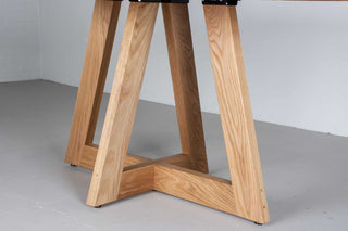 oval white oak dining table on single cross pedestal base