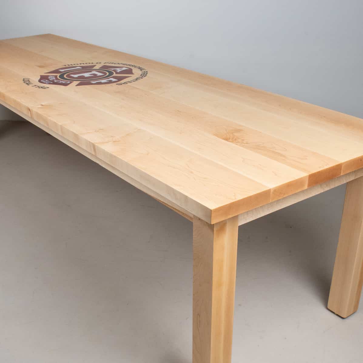 custom maple conference table with inlaid epoxy logo