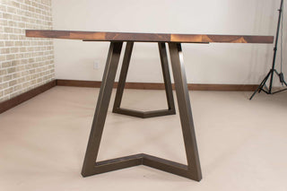 walnut table on steel chevron legs in bronze