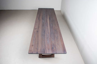 weathered walnut dining table on matching walnut trapezoid legs