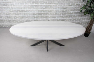white oval dining table on gunmetal steel pedestal base