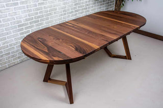 extendable oval table in walnut on walnut chevron legs