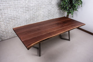 Live edge walnut table on gunmetal chevron shaped legs.