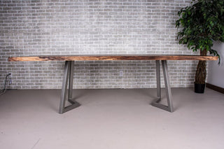 Live edge walnut table on gunmetal chevron shaped legs.