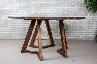 Side view of round walnut dining table. 
