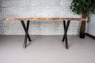 Live edge walnut table on bronze X-shaped steel legs.