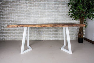Live edge walnut table on white steel chevron legs.