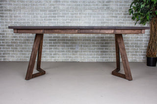 Dark wood extendable dinner table, extended with leaves inserted.
