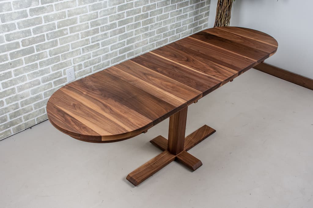 Walnut extendable dining table on a bistro pedestal.