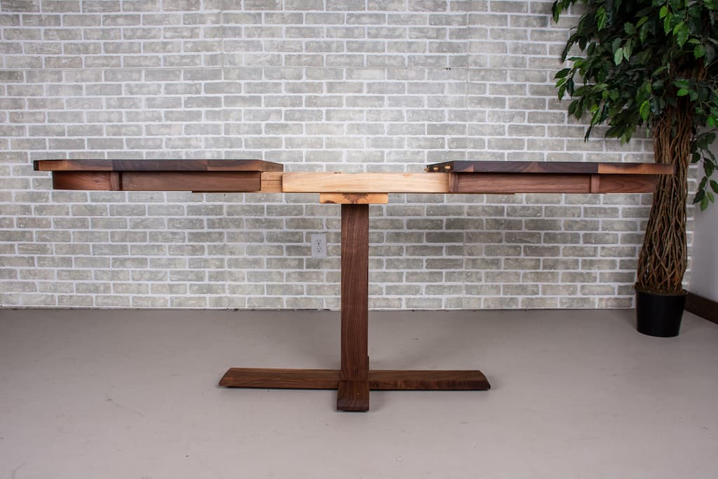 Walnut extendable dining table on a bistro pedestal.