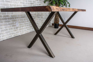 Live edge walnut table on bronze X-shaped steel legs.