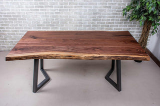 Live edge walnut table on gunmetal chevron shaped legs.