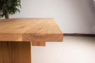 large oak dining table on wood panel legs