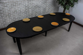 round oak extendable table in black on wood base