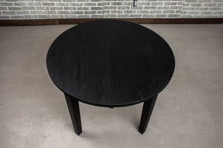 round oak extendable table in black on wood base