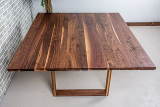 Walnut square table on square U legs.